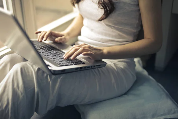 妇女坐和使用膝上型电脑在她的膝部 — 图库照片