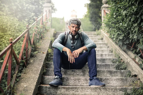 Hombre Con Barba Auriculares Mochila Sentado Una Escalera Ciudad —  Fotos de Stock