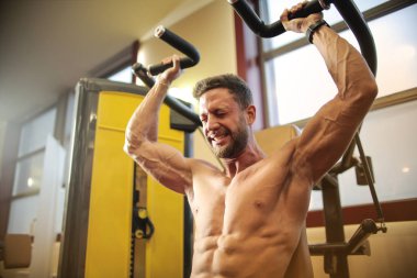 Spor salonunda sert egzersizler yapan genç atletik erkek.