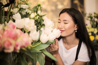 Bir çiçek dükkanı çiçek kokulu güzel Asyalı kadın.