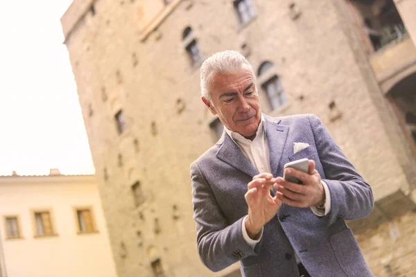 Charmig Äldre Affärsmannen Kontrollera Sin Smartphone Och Textilen Staden — Stockfoto
