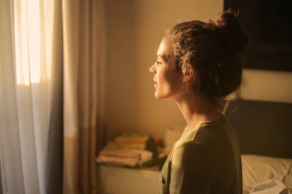 Ung Kvinna Som Tittar Genom Fönstret Solnedgången Hemma — Stockfoto