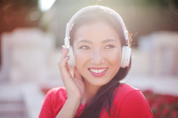美丽的亚洲妇女与耳机听音乐 — 图库照片