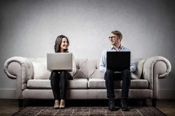 Paar Sitzt Drinnen Mit Laptop Auf Einem Sofa Und Lächelt — Stockfoto