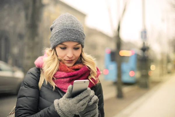 Blond Kvinna Kontrollera Hennes Smartphone Vintern Gatan Staden — Stockfoto