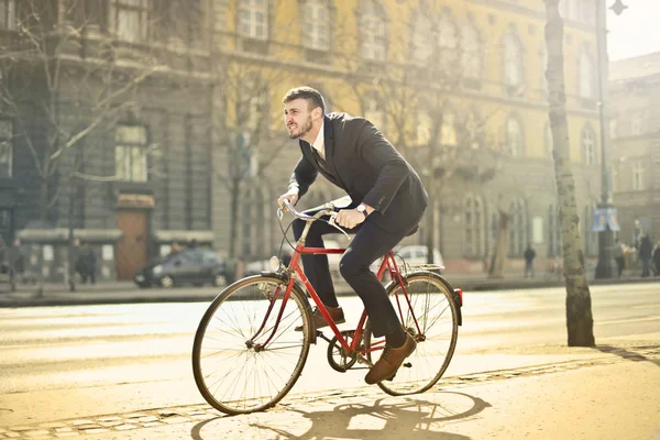 年轻的商人骑着自行车匆忙地在城里 — 图库照片