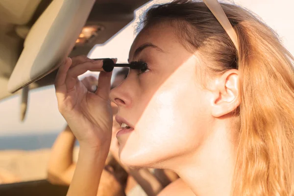 Genç kadınlar onların Make-up arabada bir tatile ayarlama.