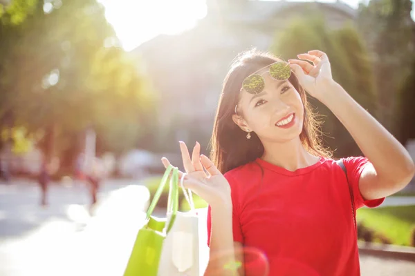 晴れた日に市内で買い物袋を持つ若いアジア女性 — ストック写真