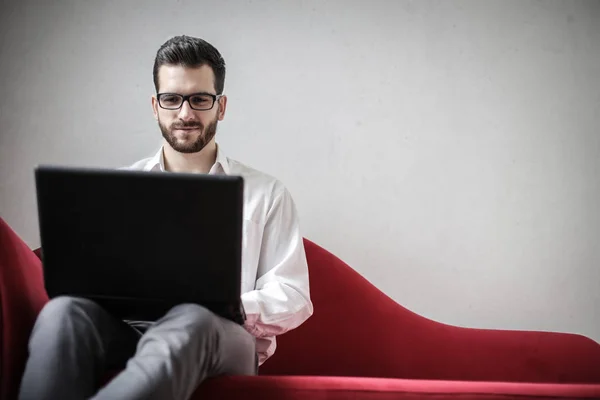 Jovem Empresário Confiante Com Óculos Laptop Sentado Sofá Trabalhando — Fotografia de Stock