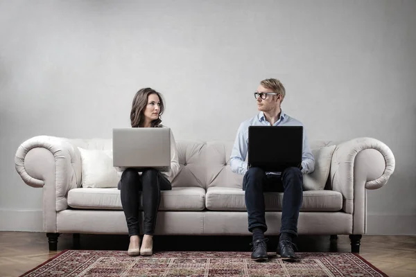 一个女人和一个男人坐在沙发上 笔记本电脑 认真地看着对方 — 图库照片