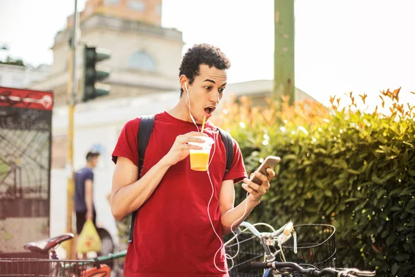 Jovem Com Fones Ouvido Uma Verificação Refrescante Surpreendentemente Seu Smartphone — Fotografia de Stock