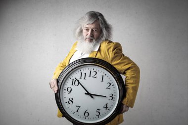 Yaşlı adam ile büyük bir masa saati.