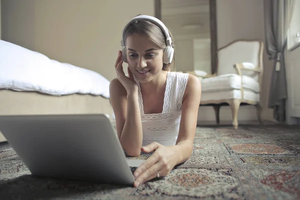 Bir Dizüstü Bilgisayar Ile Yerde Yatarken Telefonda Konuşurken Genç Kadın — Stok fotoğraf