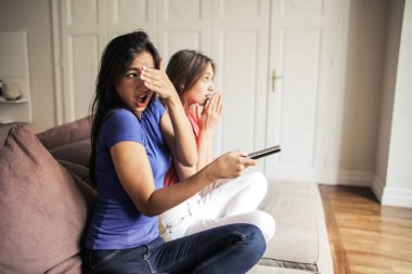 İki kadın arkadaş birlikte korkunç bir film izlerken.