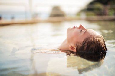 Sarışın kadın rahatlatıcı bir havuzda.