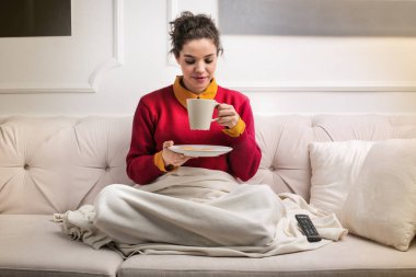 Bir bardak içki ile yatakta genç kadın.