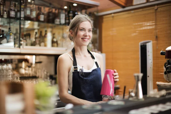 Blonde waitress working in a bar.