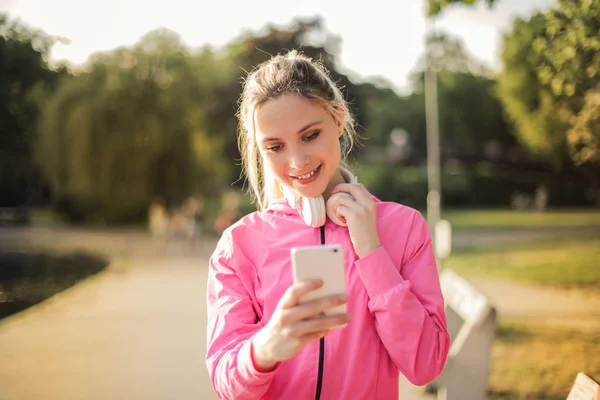 Unga Blonda Kvinnan Kontrollera Hennes Smartphone Jogging — Stockfoto