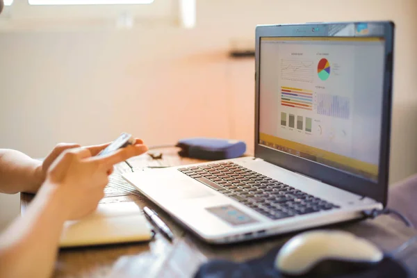 Hand Met Een Smartphone Een Laptop Het Bureau — Stockfoto