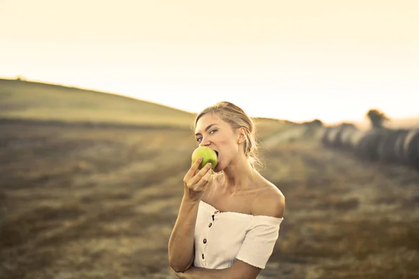 牧草地でリンゴを食べる — ストック写真