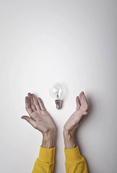 Mano Che Tiene Lampadina Luminosa Sfondo Grigio Brillante Concetto Pensiero — Foto Stock