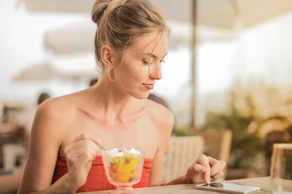 Junge Frau Isst Eis Und Liest Ihre Botschaften — Stockfoto