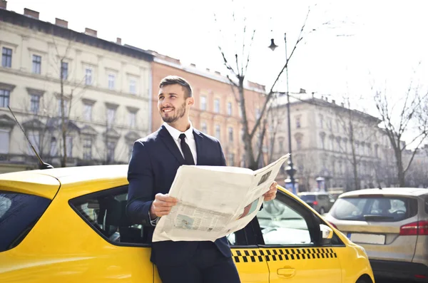 タクシーで新聞立っているハンサムな実業家 — ストック写真