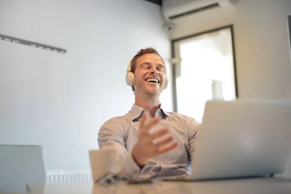Biznesmen Słuchawki Patrząc Jego Laptopie — Zdjęcie stockowe