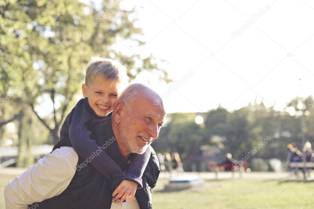 grandfather and grandson embracing each other and having fun
