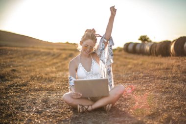 Genç kadın onu laptop bakarak ve mutlu