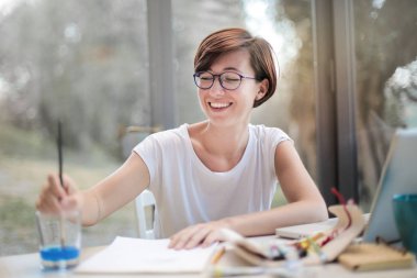 Genç kadın bir masa üzerine evde çizim