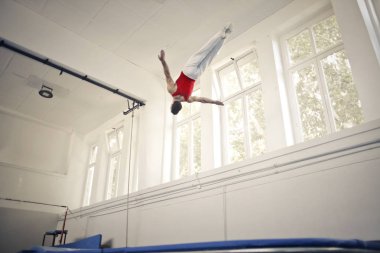 Genç acrobat spor salonunda gerçekleştirme