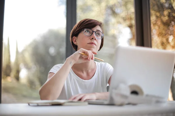 Jeune Femme Réfléchissant Devant Son Ordinateur Portable — Photo