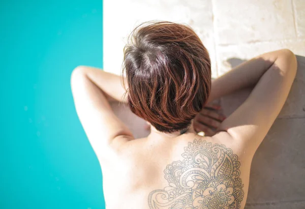 Женщина Отдыхает Бассейне Красивой Татуировкой Спине — стоковое фото