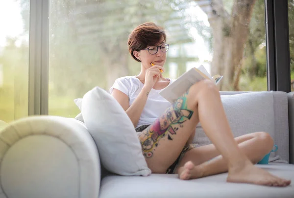若い女性の本を読んで家でのんびり — ストック写真