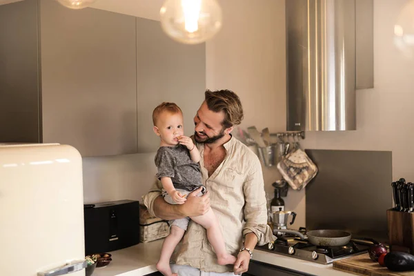 年轻英俊的父亲与他的男婴在厨房 — 图库照片