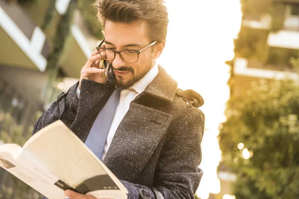 Geschäftsmann Mit Brille Telefoniert Und Ein Buch Der Hand — Stockfoto