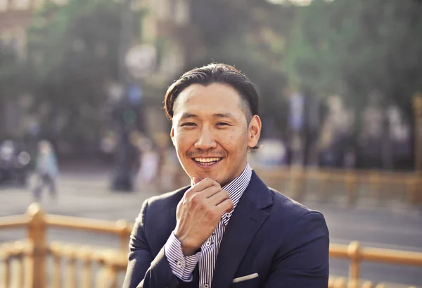 一个面带微笑的亚洲男人在街上穿着正式礼服的肖像 — 图库照片