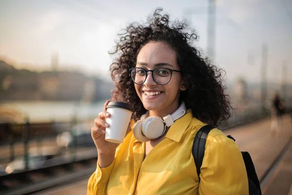 Νεαρή Γυναίκα Ακουστικά Κρατώντας Καφέ Της — Φωτογραφία Αρχείου