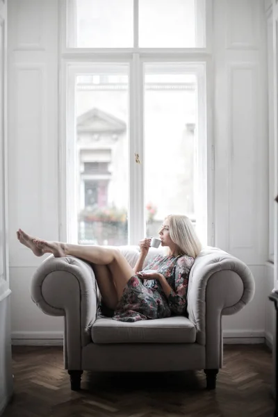 Sarışın Moda Modeli Kanepede Rahatlatıcı Pencereden Dışarı Bakıyor — Stok fotoğraf