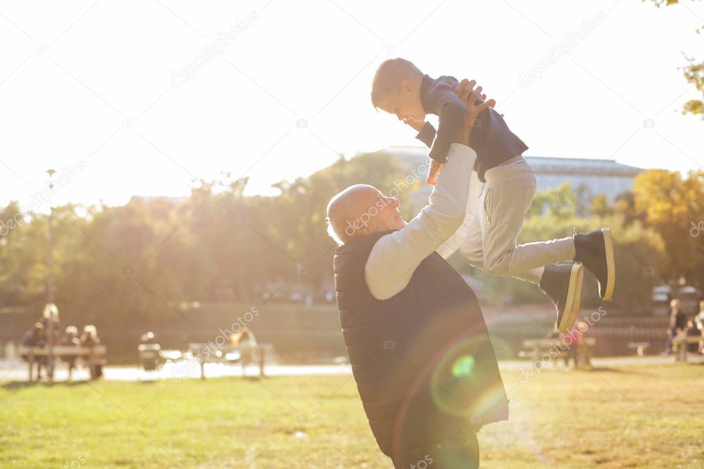 grandfather lifting up his grandson and embracing him