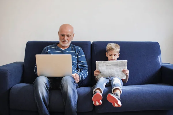 Маленький Мальчик Читает Дедушка Рядом Ним Смотрит Ноутбук — стоковое фото