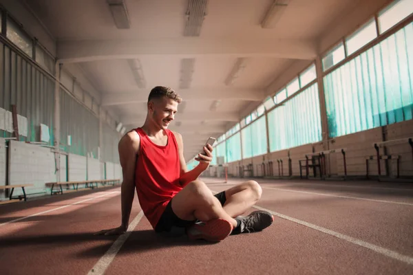 Άνδρας Αθλητής Ανάγνωση Μηνυμάτων Στο Τηλέφωνό Του Ενώ Λαμβάνει Ένα — Φωτογραφία Αρχείου