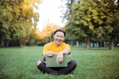 parkta dizüstü bilgisayar ile Asya adam
