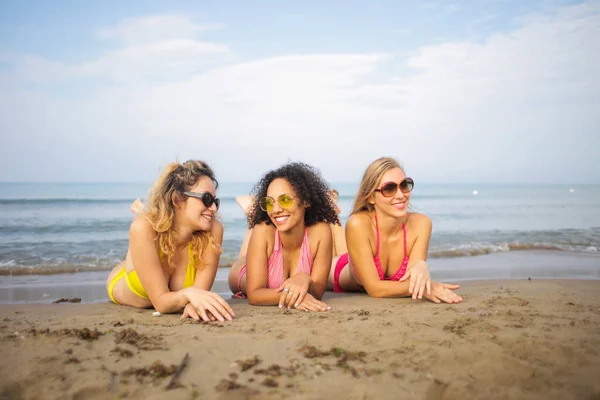 Trzy Młoda Kobieta Leżąc Uśmiechając Się Beach — Zdjęcie stockowe