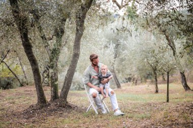 Bahçedeki erkek bebek ile genç baba