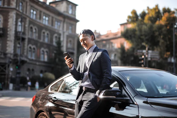 차에서 스마트폰으로 아시아 사업가 — 스톡 사진