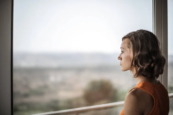 Jonge Blonde Vrouw Kijken Uit Het Venster Portret — Stockfoto