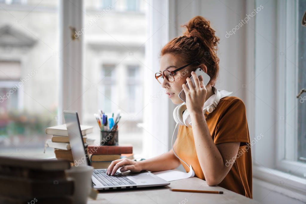 woman on the phone while working and studying