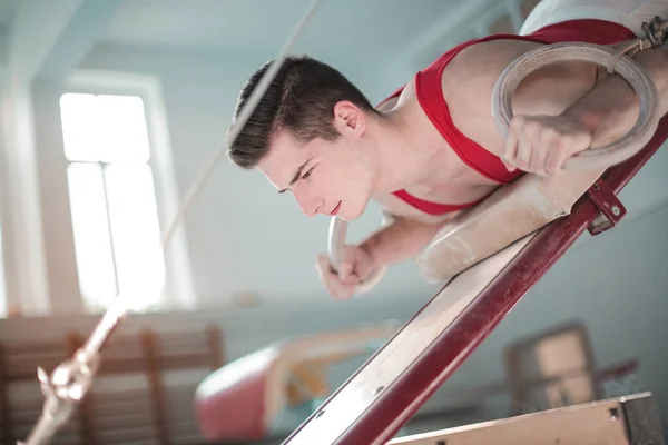 Jovem Atleta Homem Segurando Anéis Fazendo Exercícios Artísticos Ginásio — Fotografia de Stock